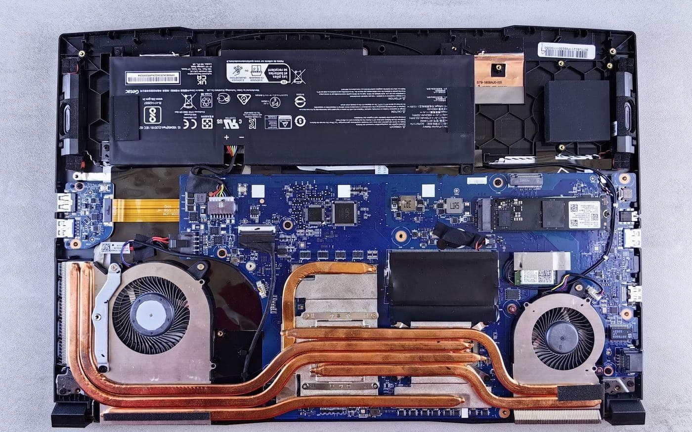 Bên trong laptop khi mở nắp lưng: pin, quạt và ống đồng tản nhiệt